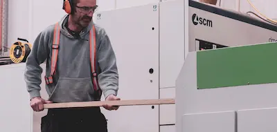 A piece of American Cherry at Timbersource's Somerset mill going through a thicknesser, being planed