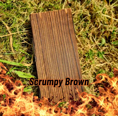 A piece of Charred (Scrumpy Brown) Larch sitting on some grass with flames at the bottom