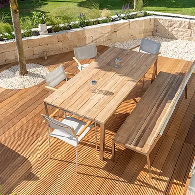 A garden table and chairs on top of a Yellow Balau deck in a garden