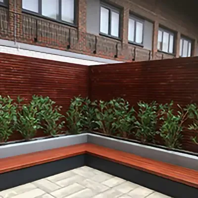 A slatted fence in a garden made from Timbersource's Meranti